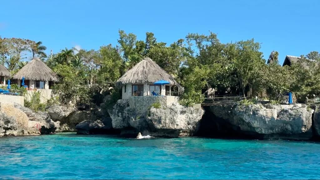 Stone cottages with thatched roofs perched on the Negril cliffs above the sea