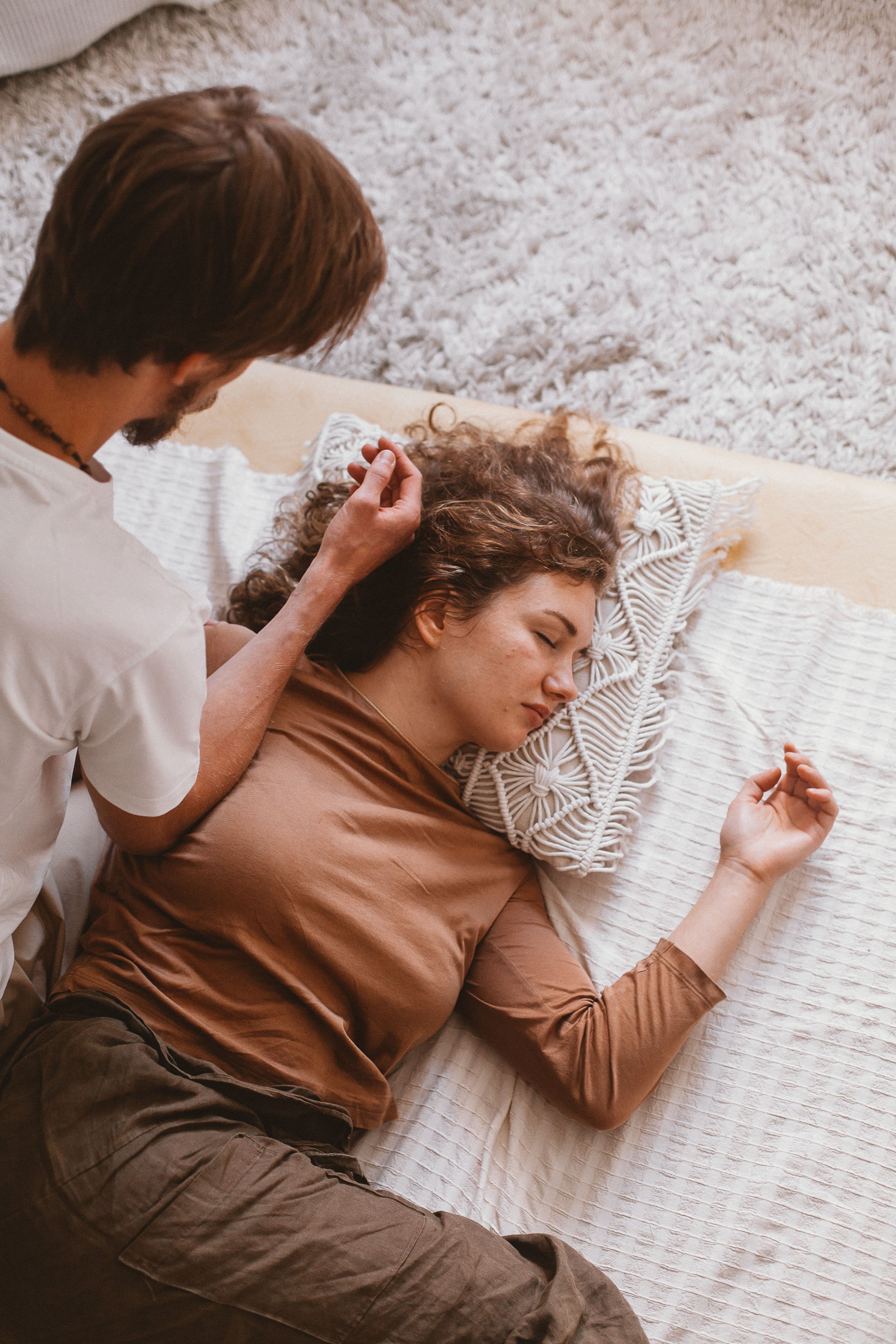 A person resting calmly while a caregiver offers a gentle, attentive supportive presence
